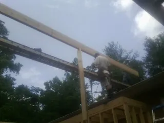 Carpenter setting a ridge beam over a new addition frame — Ice Dam Removal by Roofing Brothers in Omaha