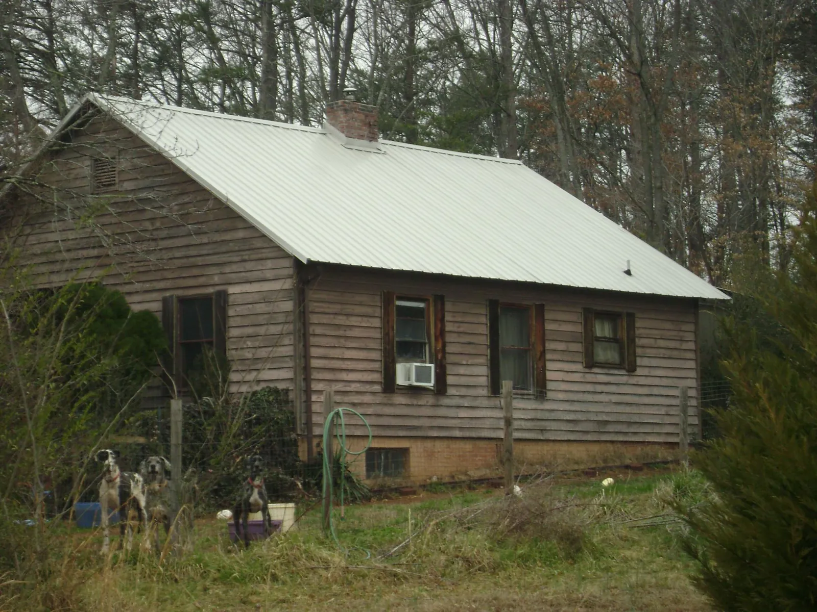 White metal roof on an old wood sided farmhouse, from a Asphalt Shingle Roof Repair job in Omaha